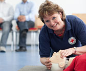 Foto: Frau übt Wiederbelebungsmaßnahmen an einer Puppe.